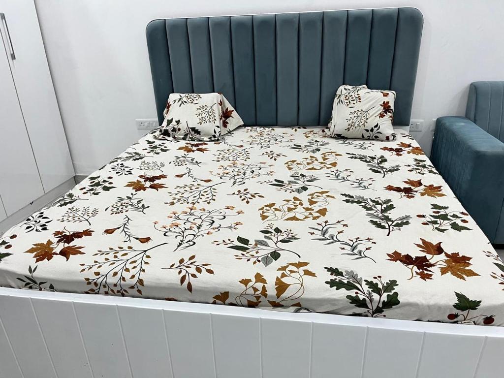 a bed with a blanket and pillows on it at Golden palace studio in Noida