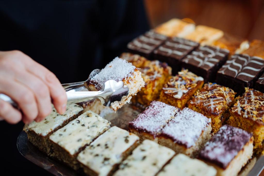 a person reaching for a plate of chocolate desserts at Hotel City in Villach