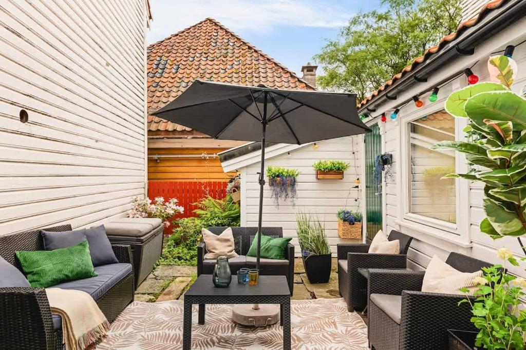 a patio with a table and an umbrella at Dinbnb Apartments I Family Dream in Bergen I Playroom I Private Garden in Bergen