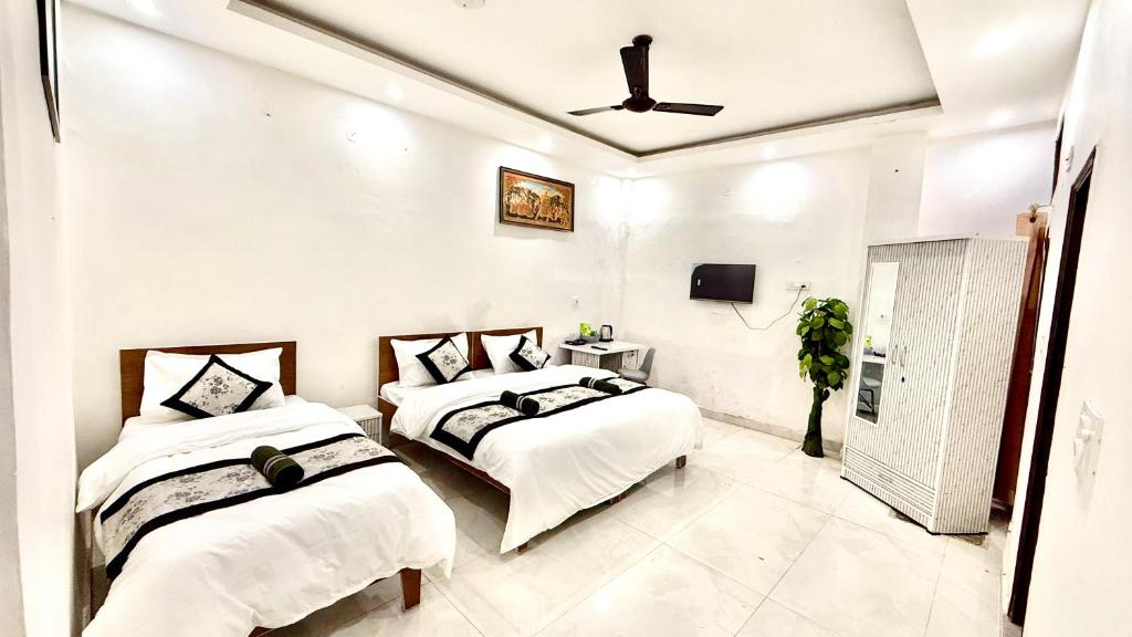 a bedroom with two beds and a ceiling fan at AB Residency in Greater Noida