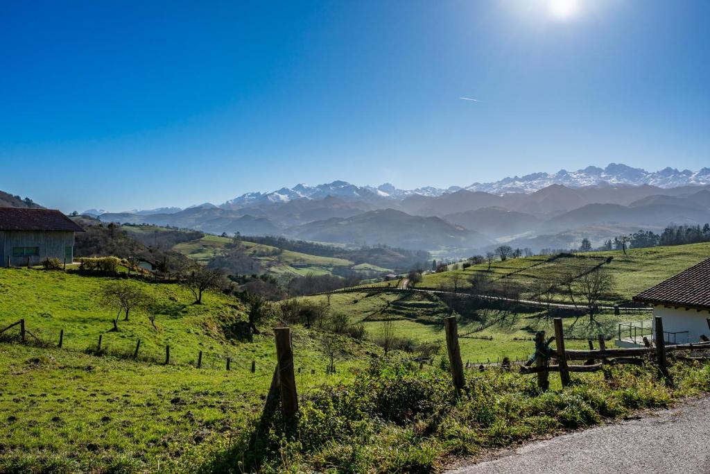 un champ avec une clôture et des montagnes en arrière-plan dans l'établissement Picuastur, à Cangas de Onís