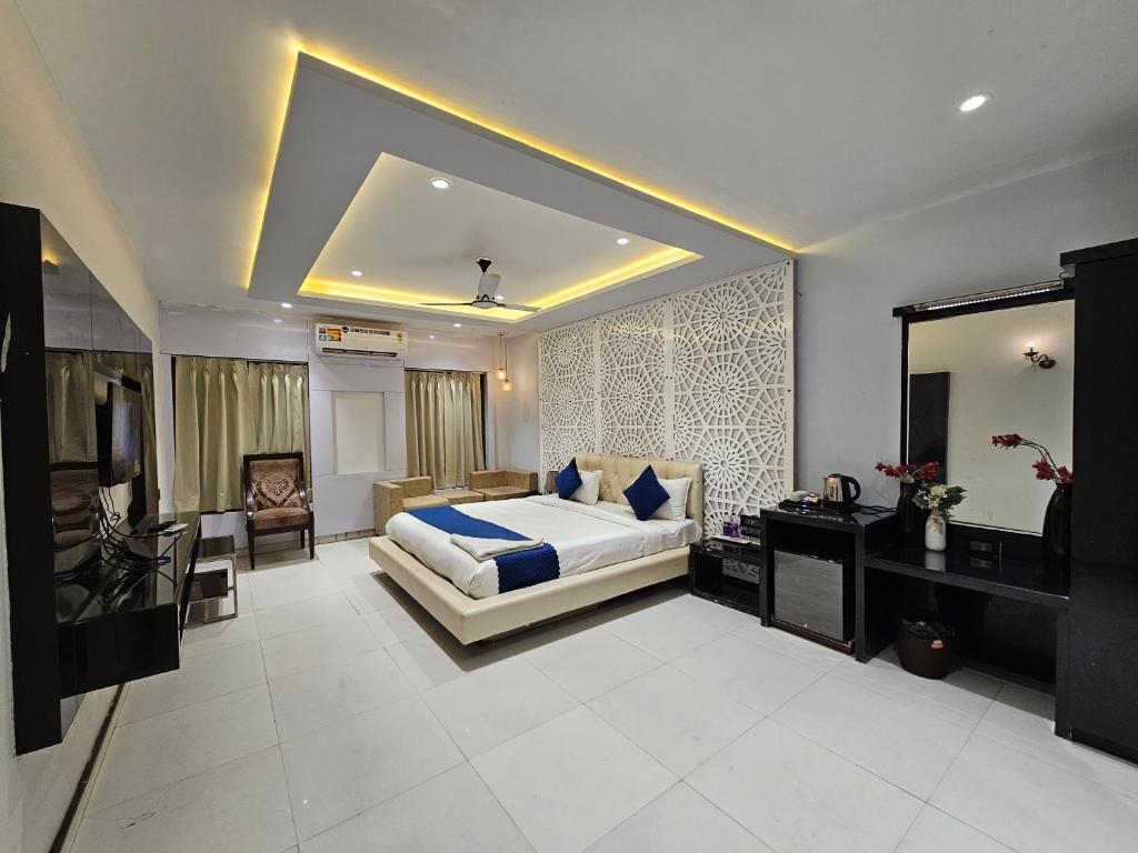 1 dormitorio con 1 cama extragrande y espejo en Hotel MK Vivanta, en Gwalior