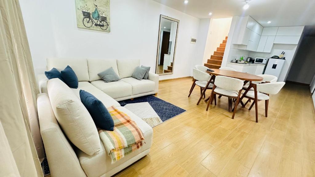 a living room with a white couch and a table at El Oasis de Huacachina - Alojamiento in Ica