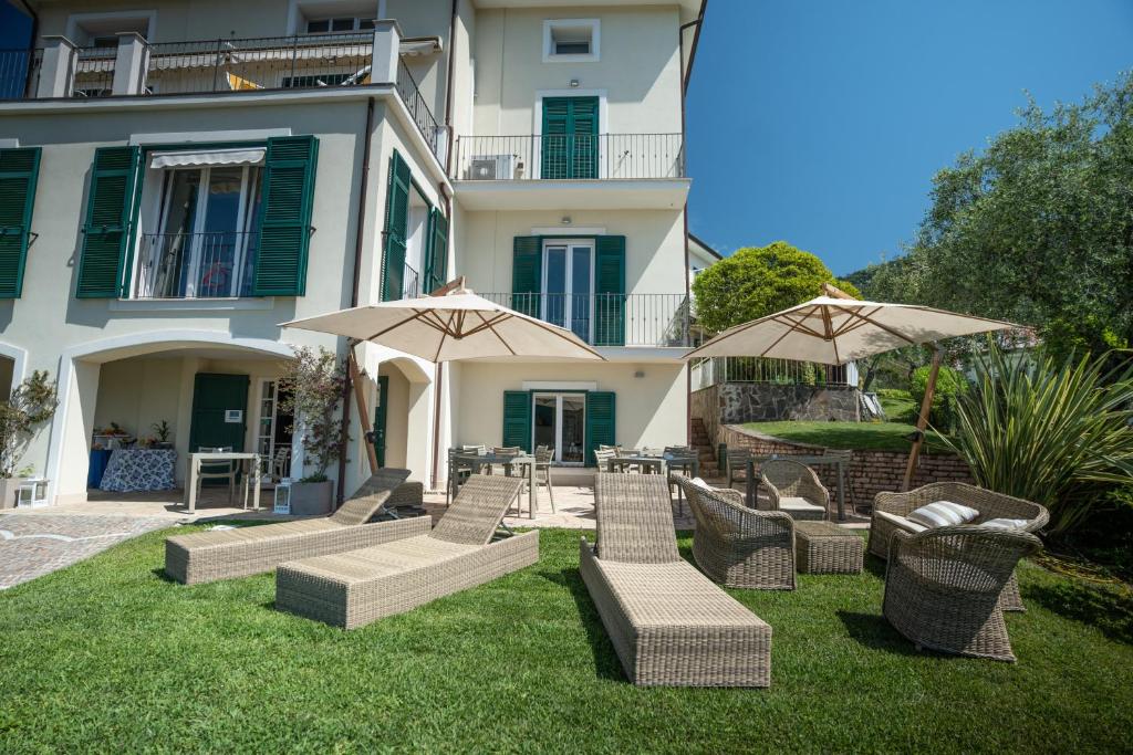 a group of chairs and umbrellas in front of a building at Albergo Blueline in Tellaro