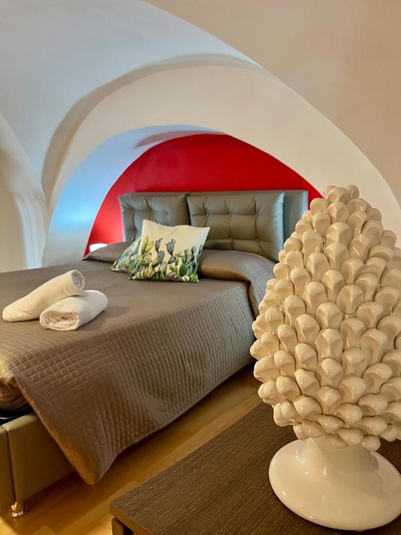 sypialnia z łóżkiem z czerwonym i białym sufitem w obiekcie Aitnè - Holiday Apartments w Katanii