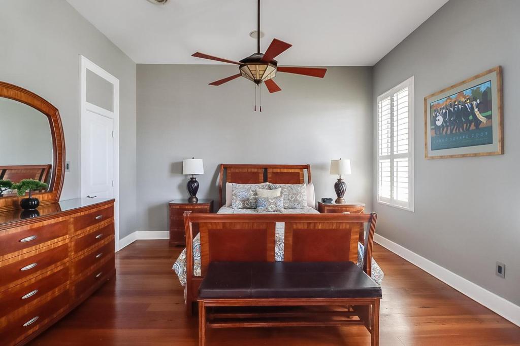 a bedroom with a bed and a ceiling fan at Seaside Creole Cottage in Gulfport