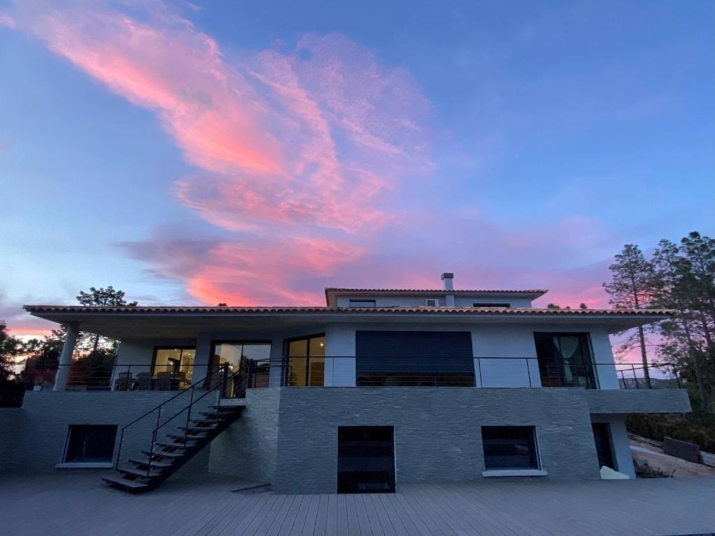 une maison avec un coucher de soleil dans le ciel dans l'établissement Villa - Porto-Vecchio - Piscine privée, à Porto-Vecchio
