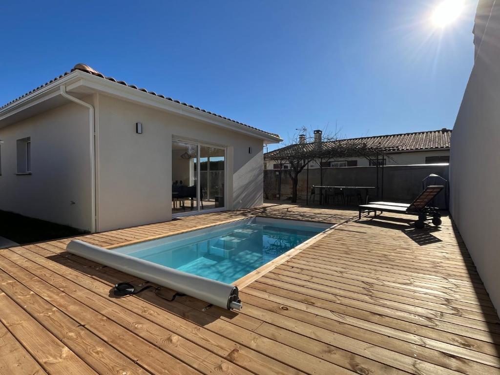 居让梅斯特拉Maison familiale piscine 3 chambres Gujan-Mestras !的一个带长凳的木甲板上的游泳池