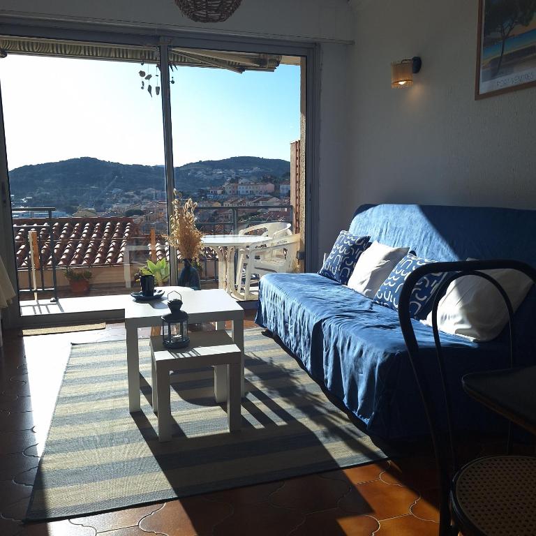 une chambre avec un lit et une table et une grande fenêtre dans l'établissement T2 belle terrasse avec vue sur mer, à Port-Vendres