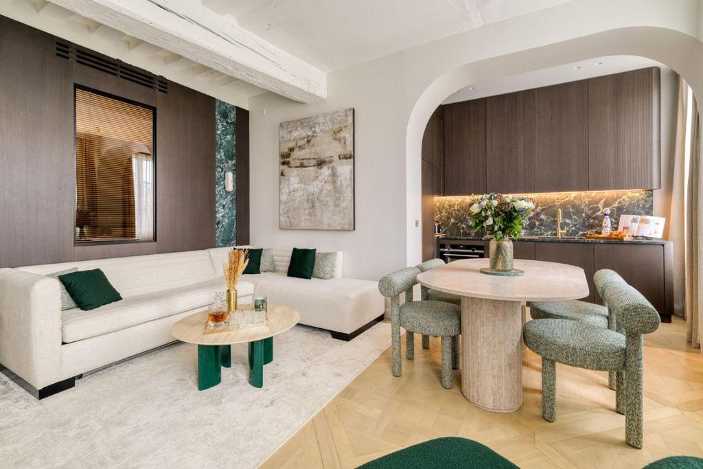 un salon avec un canapé et une table dans l'établissement Oniri - Serviced Apartments Notre Dame - Quai des Grands Augustins, à Paris