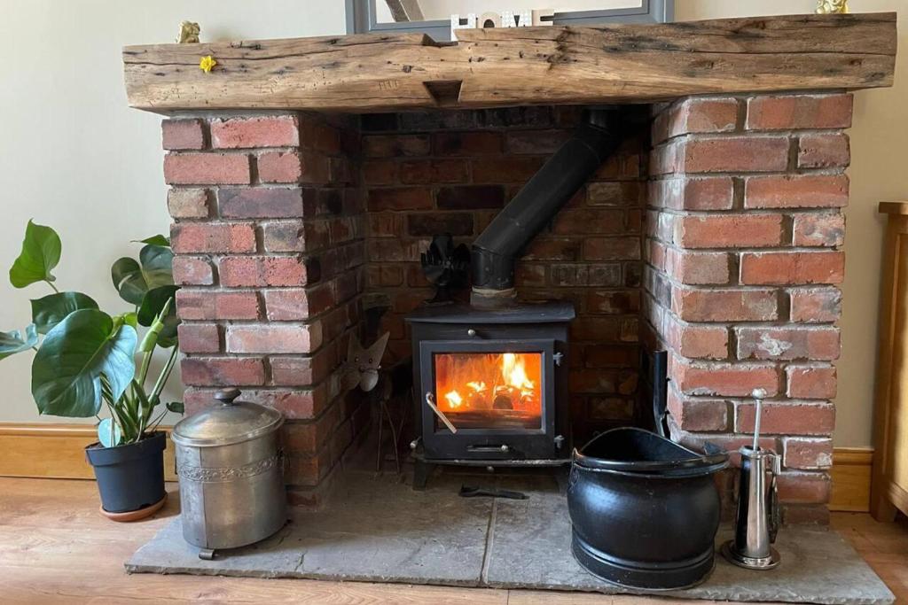 a brick fireplace with a fire in it at 2Bed Cottage - Trawden - Pet Friendly - Sleeps4 in Colne