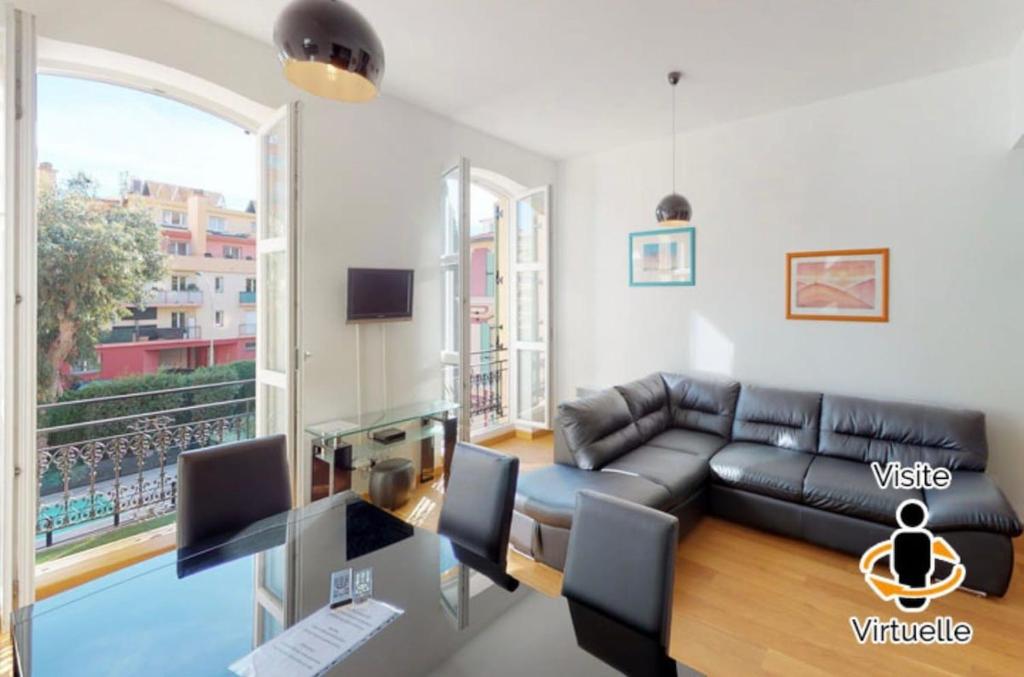 - un salon avec un canapé en cuir noir et une fenêtre dans l'établissement Superb 50m2 condominium apartment with swimming pool, à Menton