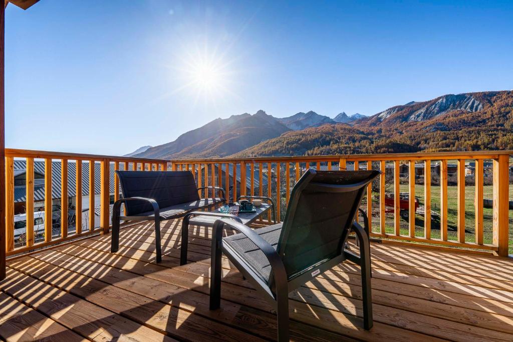 - deux chaises sur une terrasse avec vue sur les montagnes dans l'établissement Le Cerf Che, au Monêtier-les-Bains