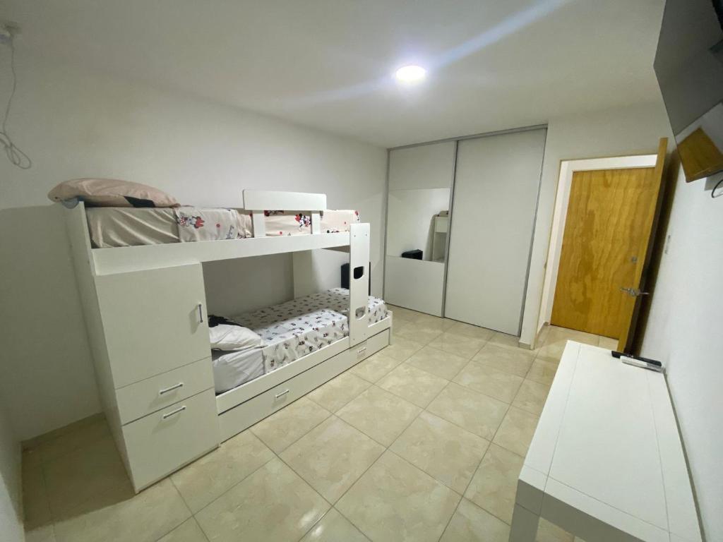 a white room with two bunk beds and a mirror at Amalia Apart in San Rafael