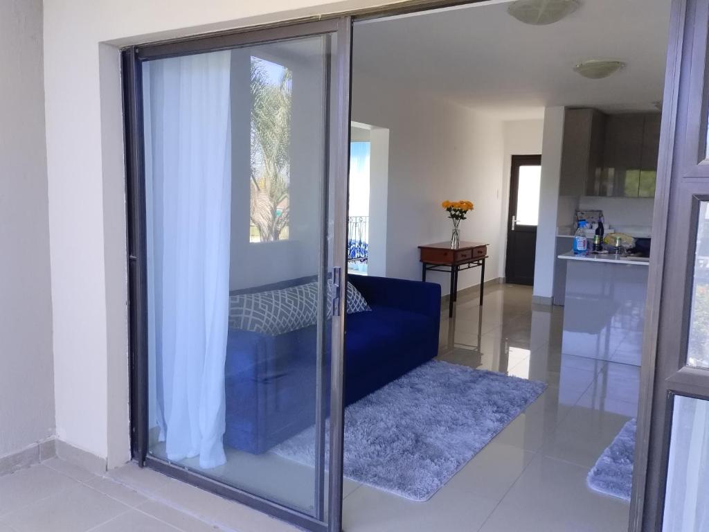 Sala de cristal con sofá azul en la sala de estar en Croydon Cove, en Port Alfred