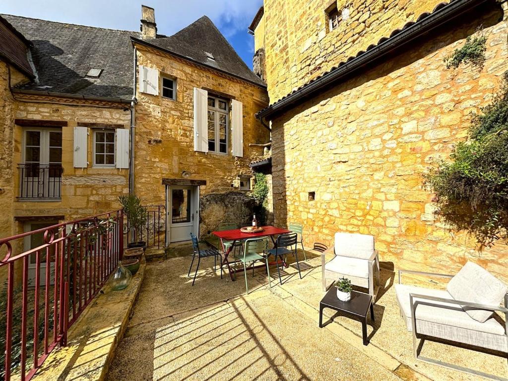a balcony with a table and chairs and a building at Le Secret de St Cyprien in Saint-Cyprien