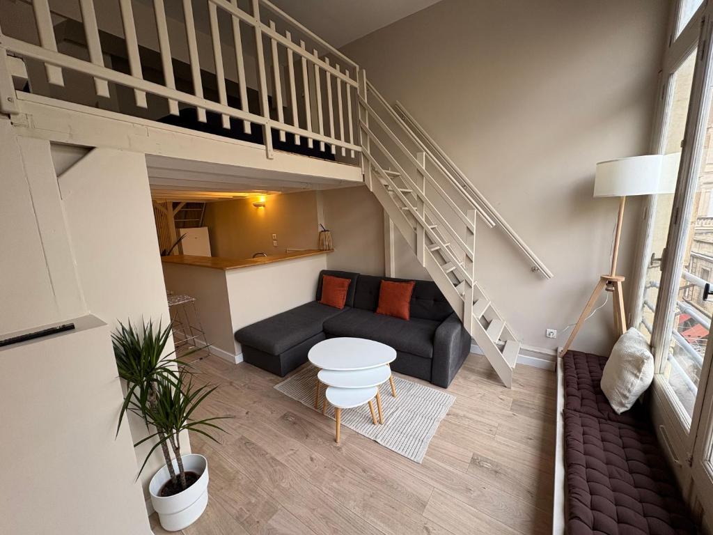 un salon avec un canapé et un escalier dans l'établissement L'Atlas de la Comédie, à Montpellier