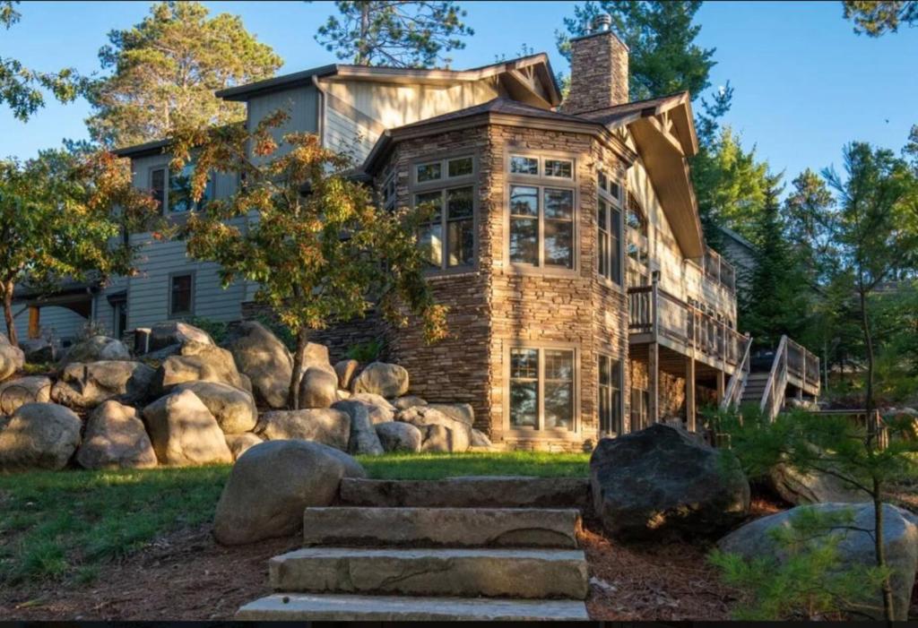 a stone house with large rocks in front of it at Stony Crest Cabin Deer Lake in Three Lakes