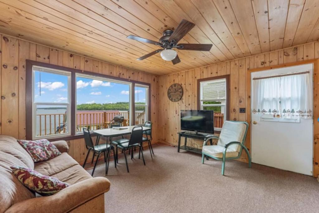 un salon avec un canapé et une table avec des chaises dans l'établissement TB6 Thunder Bay Resort Cabin 6, à Phelps