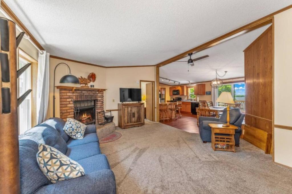 a living room with a blue couch and a fireplace at TB-15 Thunder Bay Resort Cabin15 in Phelps