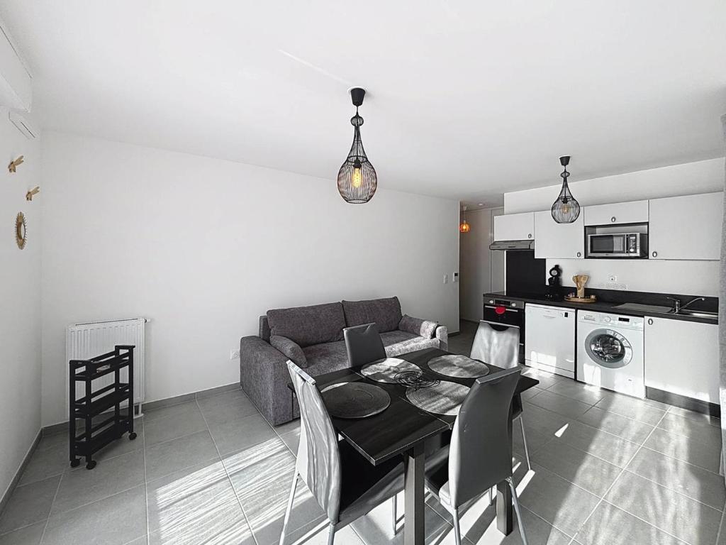 un salon avec un canapé et une table et une cuisine dans l'établissement Charmant appartement proche plage avec balcon et parking privé - FR-1-465-123, à Cabourg