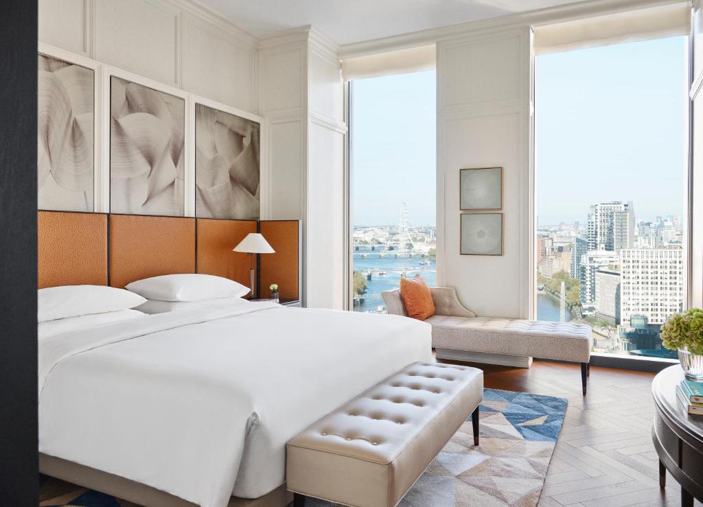 a bedroom with a large white bed and a large window at Park Hyatt London River Thames in London