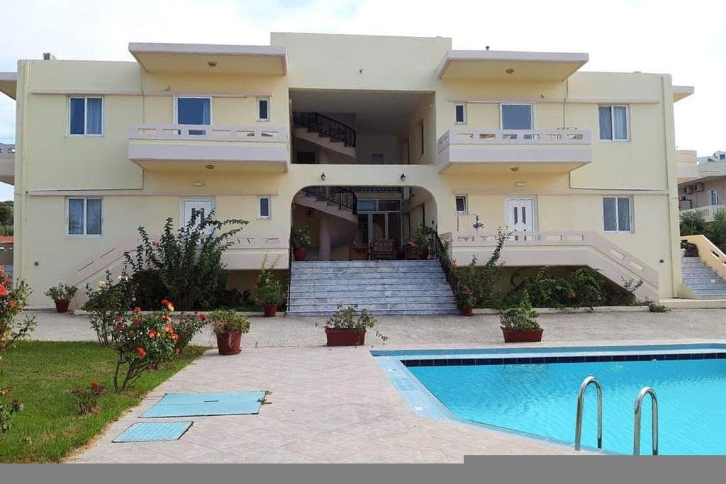 a large house with a swimming pool in front of it at Litinas Apartments with pool in Agia Marina Nea Kydonias
