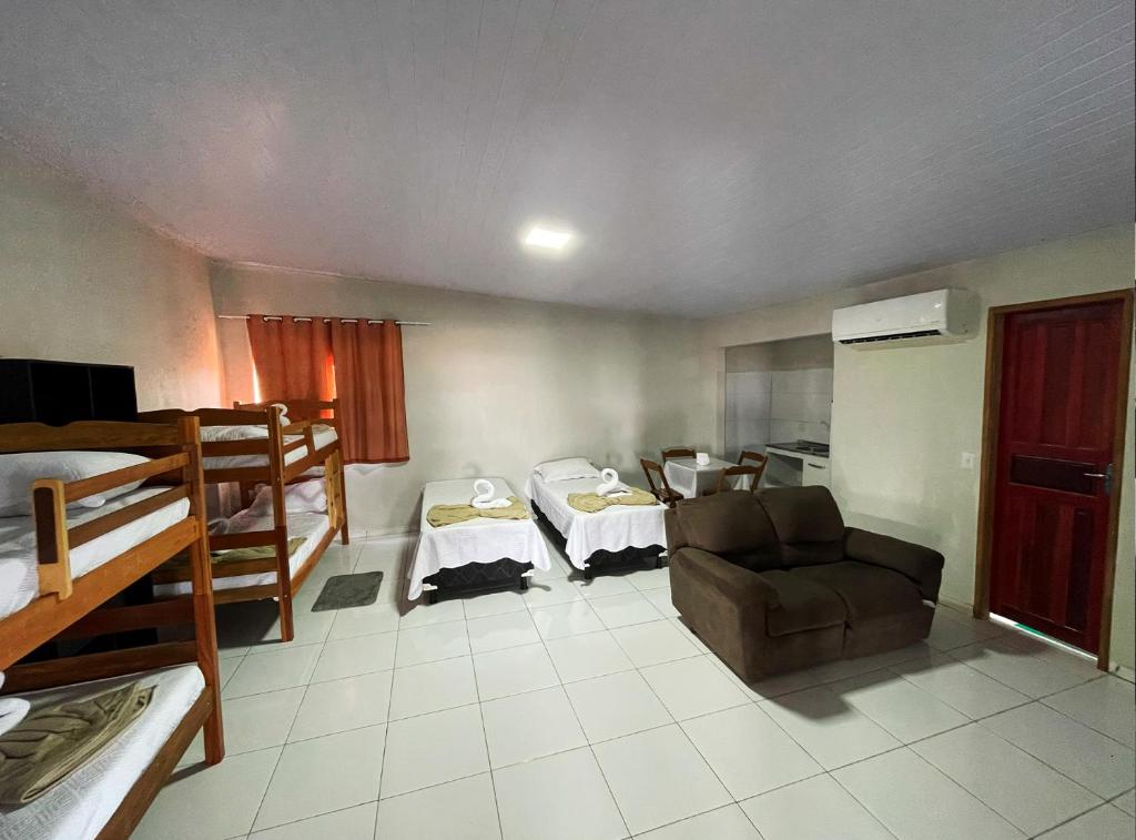 een kamer met 2 stapelbedden en een bank bij Sol lar hotel flats in Paragominas
