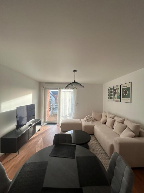 un salon avec un canapé et une télévision dans l'établissement Appartement chaleureux proche du centre et de la plage, à Crozon