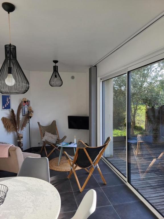 a living room with a table and chairs and a sliding glass door at Baie du Mont-Saint-Michel et Côte Normande - Les Secrets du Rivage in Saint-Pair-sur-Mer