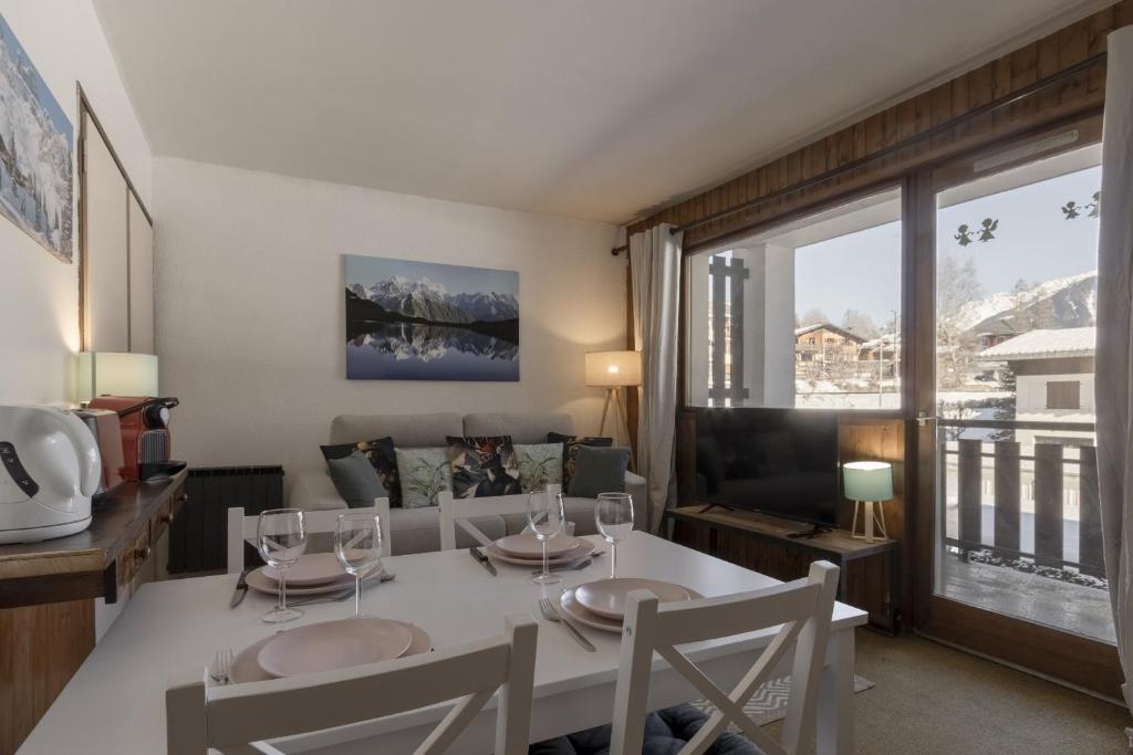 un salon avec une table, des chaises et un canapé dans l'établissement Le Miage, à Chamonix-Mont-Blanc