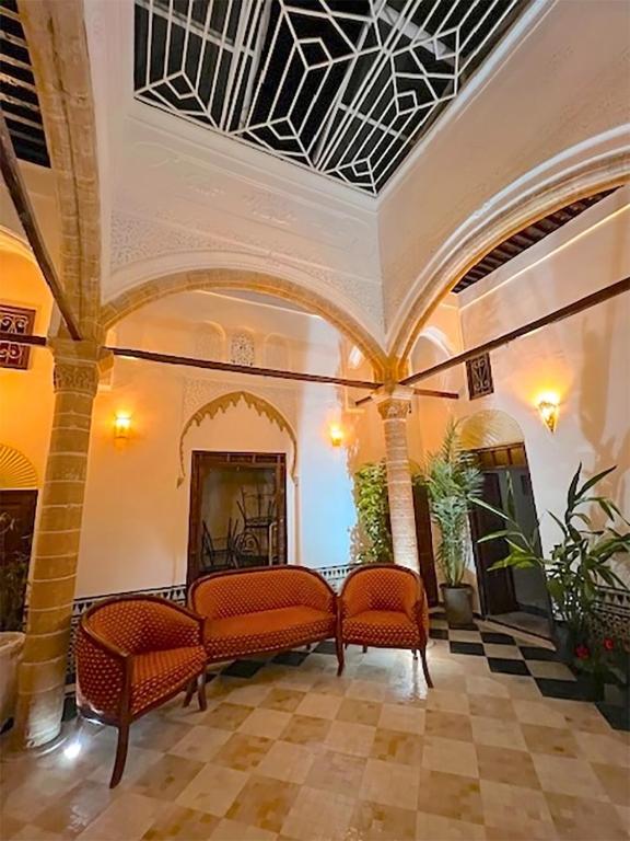a living room with two chairs and a fireplace at Riad Dar Chaafa 17 in Salé