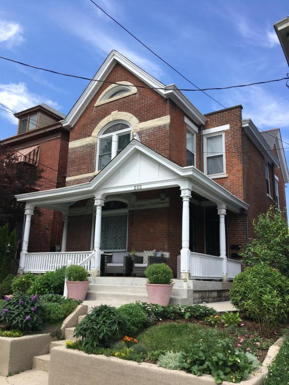 a red brick house with a white porch at Historic Upstairs Apartment in Bellevue