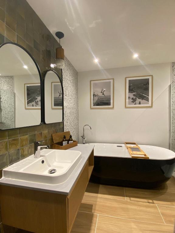 a bathroom with a bath tub and a large sink at De bank van Nagele in Nagele