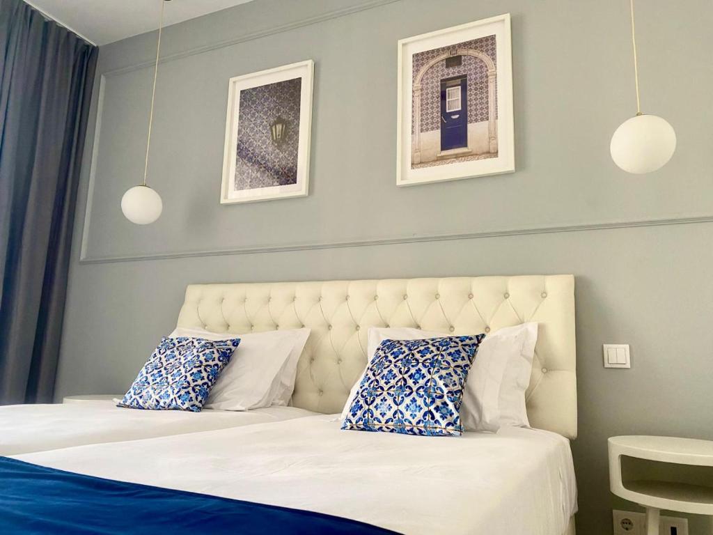 a bedroom with two beds with blue and white pillows at Lisbon City Inn Hotel by City Hotels in Lisbon