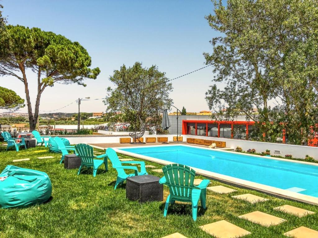 a swimming pool with chairs and a poolvisorvisor at Charming House with Pool in Atalaia in Lourinhã