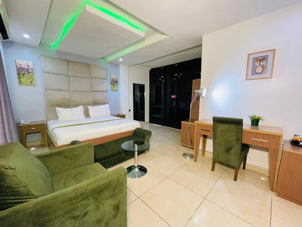 una camera d'albergo con un letto, un divano e una scrivania di The Tranquil Mews ad Abuja