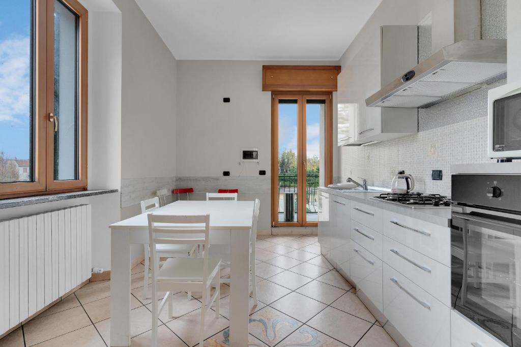 a white kitchen with a white table and chairs at MUG1 -Sesto San Giovanni- Comfort House - in Sesto San Giovanni