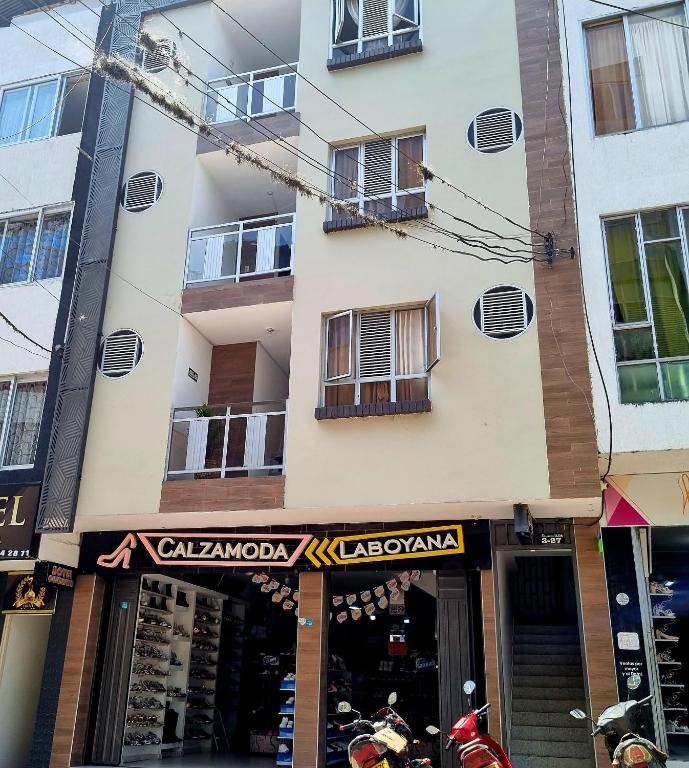 a store in front of a tall building at Hotel Iloa in Pitalito