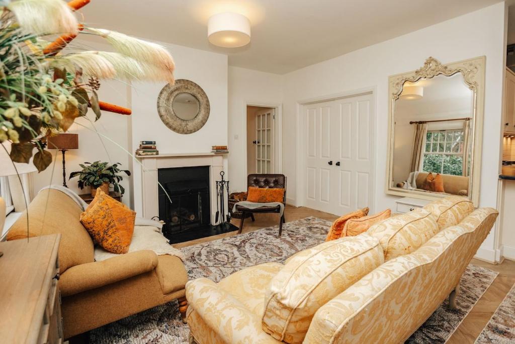 a living room with a couch and a fireplace at Badgemore Cottage in Henley on Thames