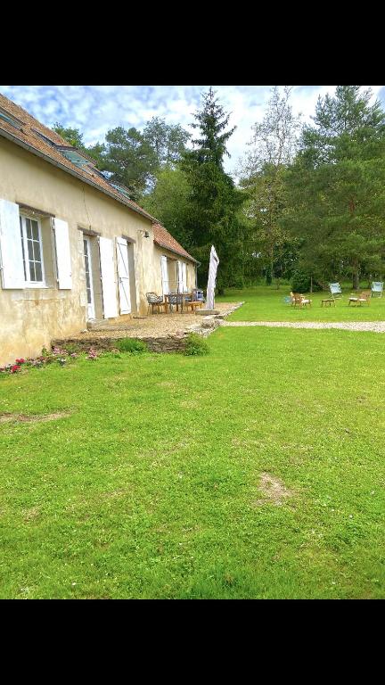 une grande cour avec un bâtiment et une table de pique-nique dans l'établissement Le gite d Henri, à La Flèche