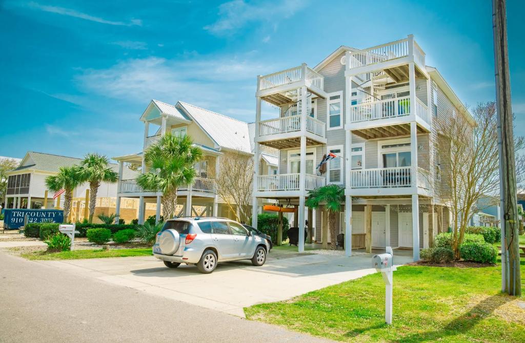 Fancy Flounder في كارولينا بيتش: منزل فيه سيارة متوقفة أمامه