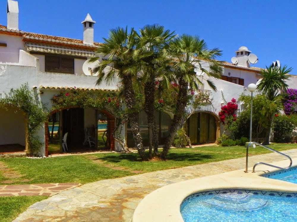 una casa con una palmera y una piscina en Tropicana Park Fase II - TP33 Duplex bungalow, en Denia