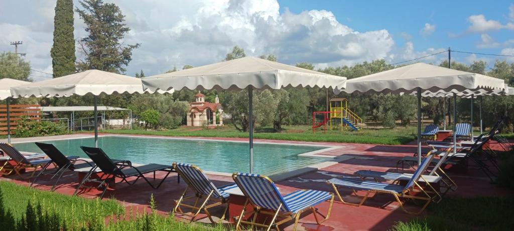 a group of chairs and umbrellas next to a pool at Rock Rooms in Lefkada