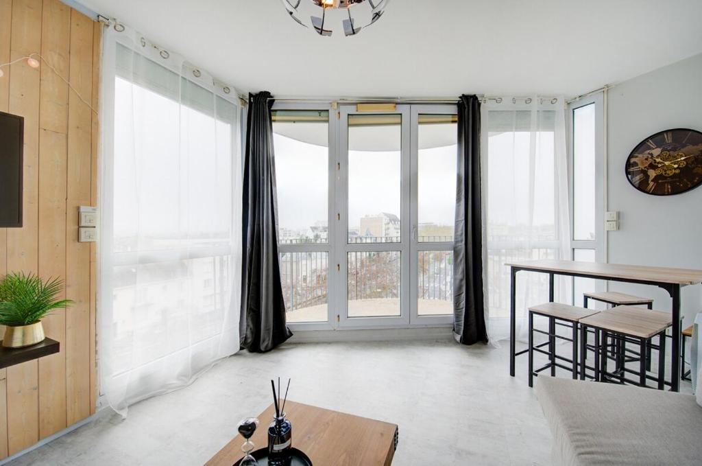 ein Wohnzimmer mit Tisch und großem Fenster in der Unterkunft Appartement Cosy proche Gare in Tours