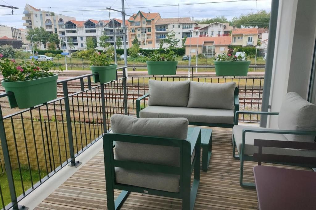 d'un balcon avec des chaises et un canapé. dans l'établissement Cozy renovated apartment behind Arcachon station, à Arcachon