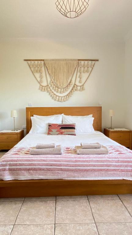 a bedroom with a large bed with two pillows at Casa Lua Guesthouse in Burgau