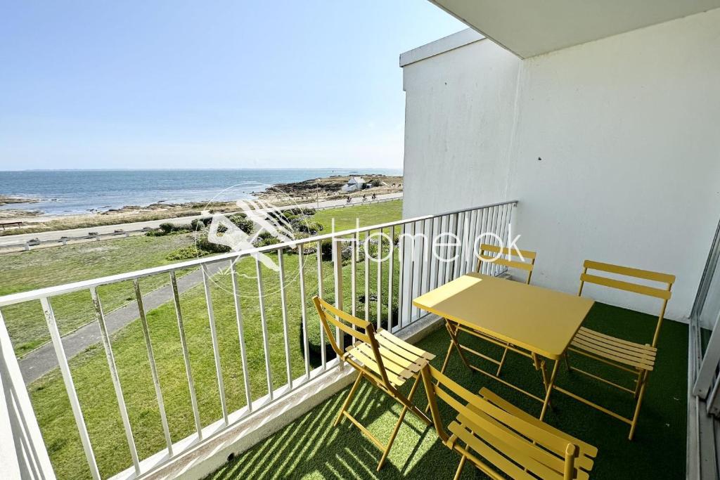 un balcon avec une table et des chaises et l'océan dans l'établissement Appartement Top Cocooning Vue mer 180, à Quiberon