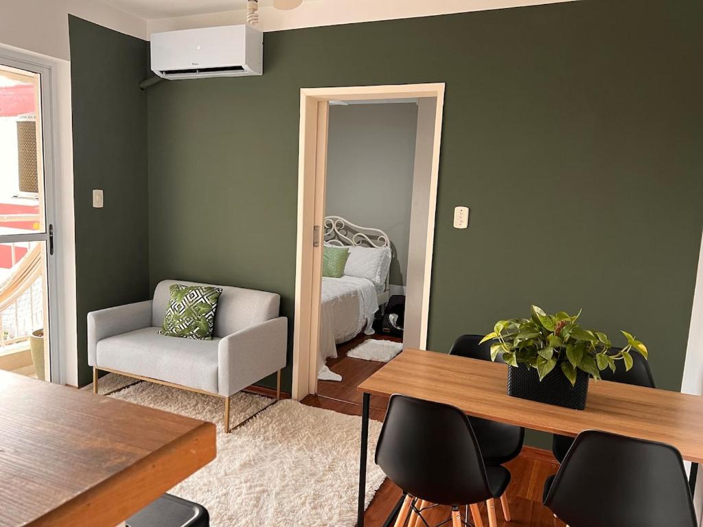 a living room with green walls and a table and chairs at Next to the Mall - Air Conditioning in São José dos Campos
