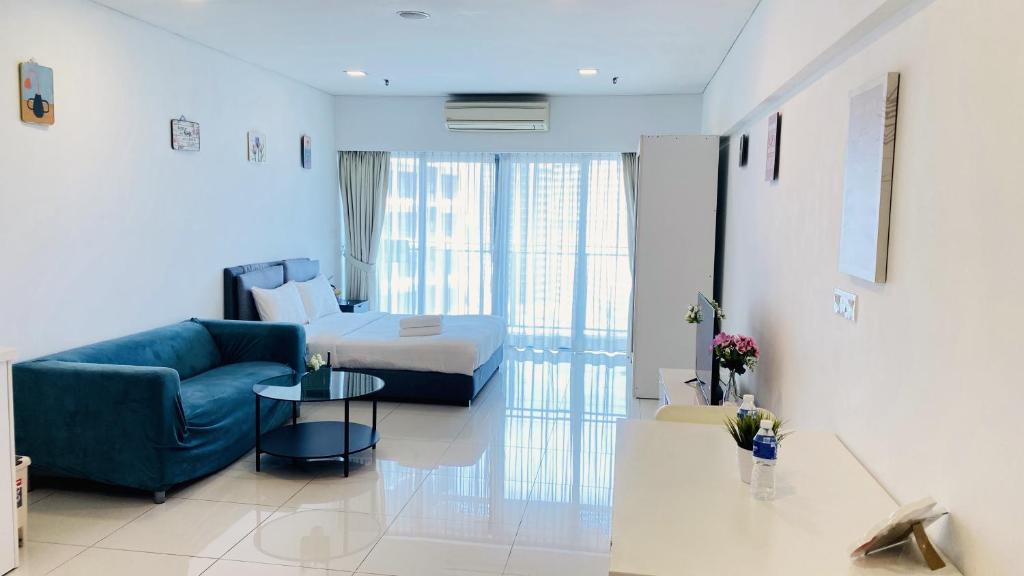 a living room with a blue couch and a bed at Summer Suites by Western Holiday in Kuala Lumpur